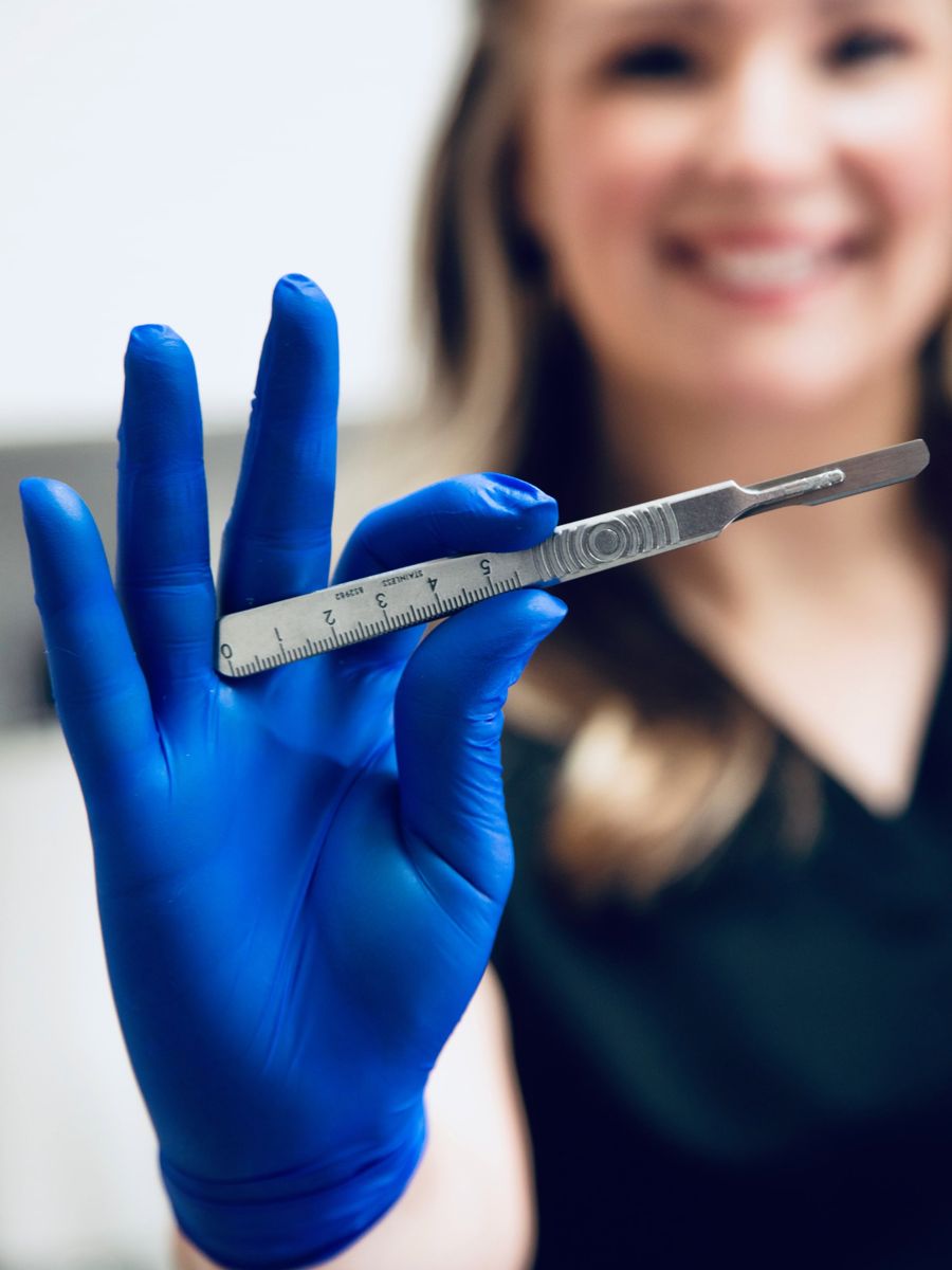 Esthetician holding a dermaplaning blade