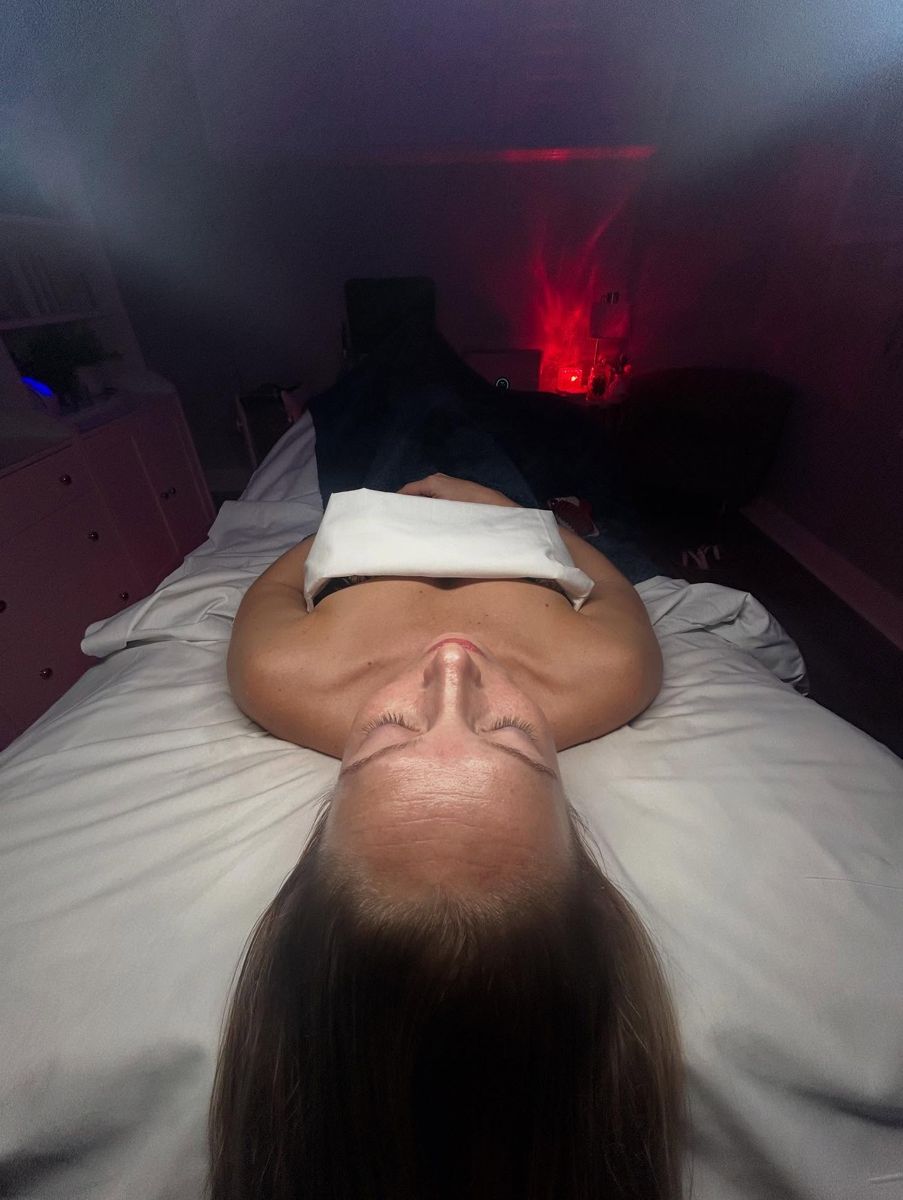 Dimly lit treatment room with client relaxing